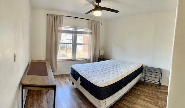 bedroom with baseboards, ceiling fan, and wood finished floors