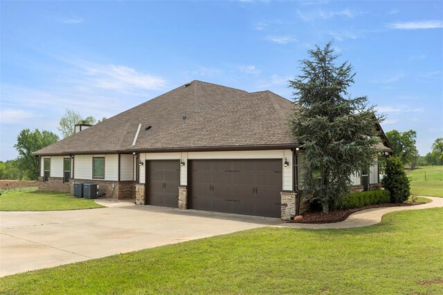 view of front of house with a garage, a front lawn, cooling unit, roof with shingles, and driveway