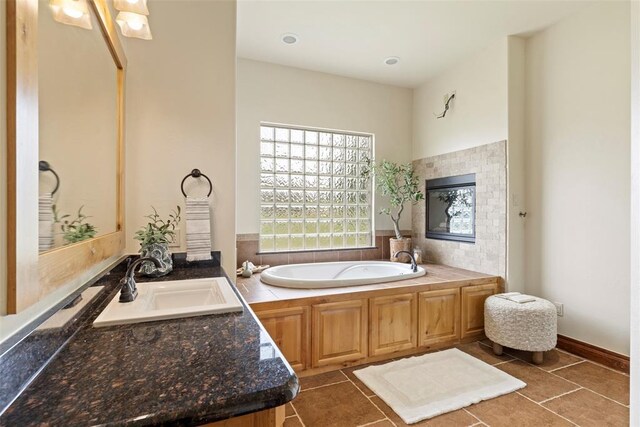 bathroom featuring vanity, tile patterned floors, and a bath