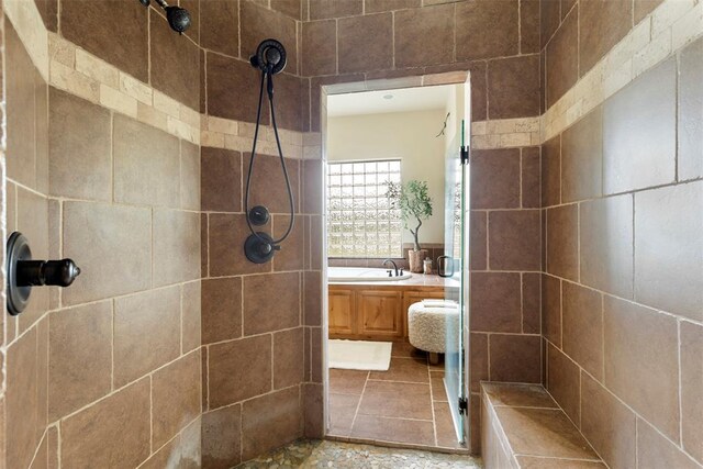 full bathroom with a sink, a garden tub, and tiled shower