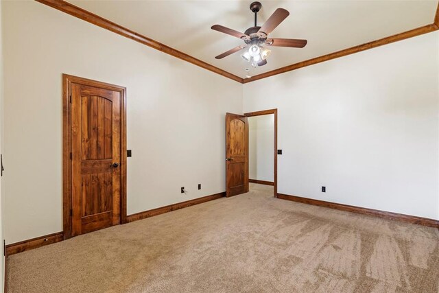 unfurnished room featuring baseboards, a ceiling fan, crown molding, and light carpet