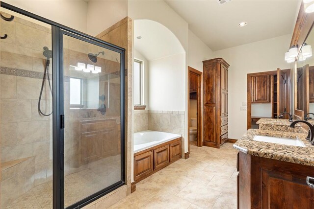 bathroom featuring vanity, tile patterned flooring, toilet, a bath, and a stall shower