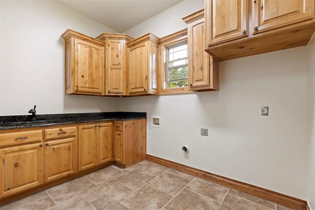 laundry room featuring electric dryer hookup, cabinet space, a sink, baseboards, and hookup for a washing machine