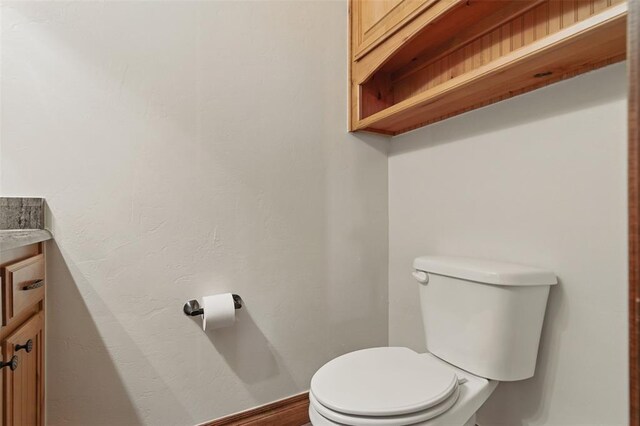 half bath featuring toilet and vanity