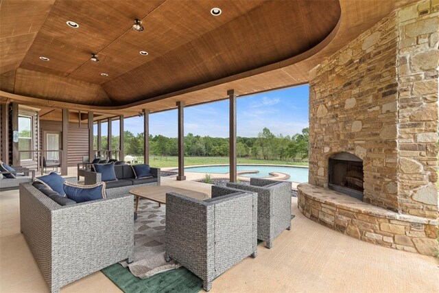 view of patio featuring an outdoor living space with a fireplace and a pool
