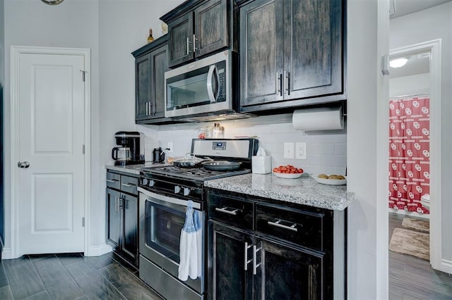 13313 Watson Dr, Piedmont, OK 73078 - kitchen with baseboards, tasteful backsplash, light stone counters, dark wood finished floors, and appliances with stainless steel finishes