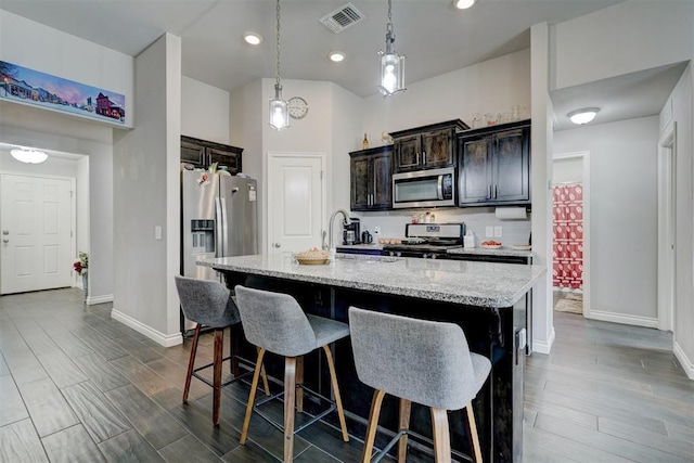 13313 Watson Dr, Piedmont, OK 73078 - kitchen with visible vents, baseboards, a kitchen breakfast bar, dark wood finished floors, and appliances with stainless steel finishes