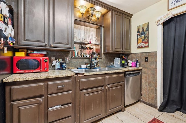 5720 12th Ave NW, Norman, OK 73069 - kitchen with stainless steel dishwasher, a sink, tile walls, light countertops, and light tile patterned floors