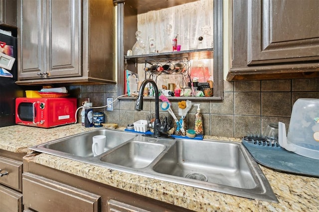 5720 12th Ave NW, Norman, OK 73069 - kitchen featuring a sink, light countertops, decorative backsplash, and dark brown cabinetry