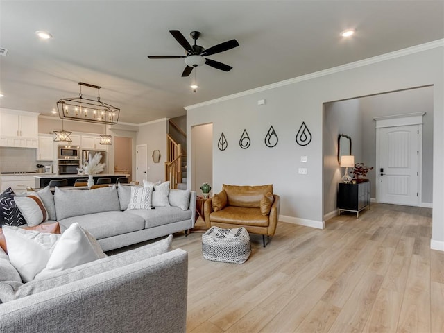 18444 Posse Trl, Norman, OK 73071 - living room featuring a ceiling fan, crown molding, baseboards, light wood finished floors, and stairs