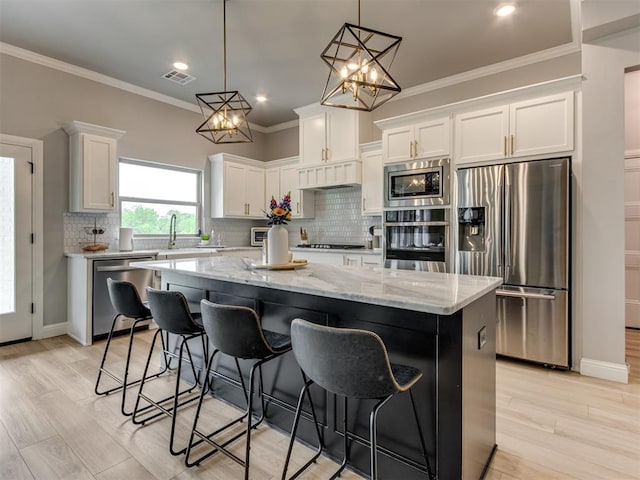 18444 Posse Trl, Norman, OK 73071 - kitchen featuring visible vents, decorative backsplash, a kitchen island, white cabinets, and stainless steel appliances