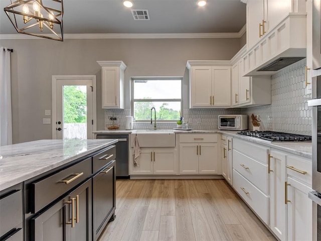 18444 Posse Trl, Norman, OK 73071 - kitchen with white cabinets, a sink, light wood-style floors, stainless steel appliances, and visible vents