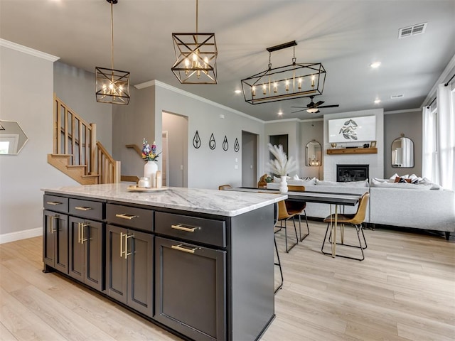 18444 Posse Trl, Norman, OK 73071 - kitchen with crown molding, visible vents, a kitchen island, and ceiling fan with notable chandelier