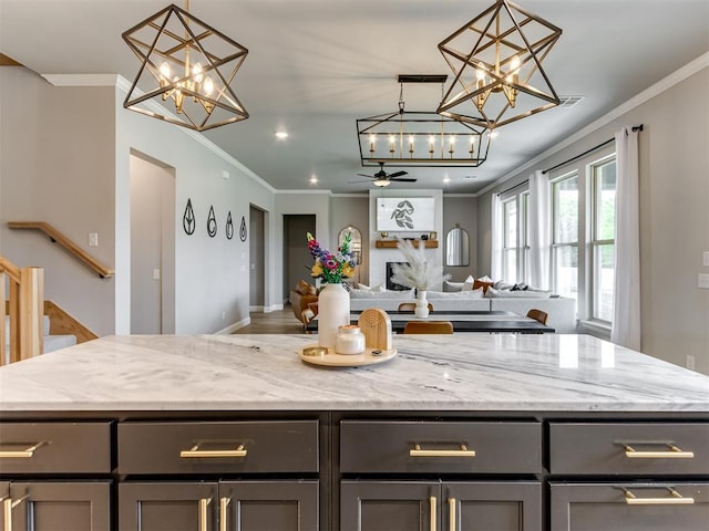 18444 Posse Trl, Norman, OK 73071 - kitchen with a kitchen island, light stone countertops, open floor plan, and ornamental molding