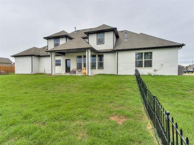 18444 Posse Trl, Norman, OK 73071 - rear view of house with a yard, fence, and a shingled roof