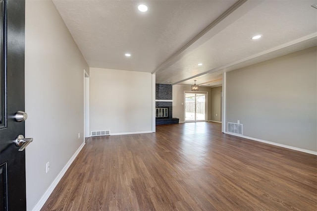 1508 Carlton Way, Oklahoma City, OK 73120 - unfurnished living room with a brick fireplace, baseboards, visible vents, and wood finished floors