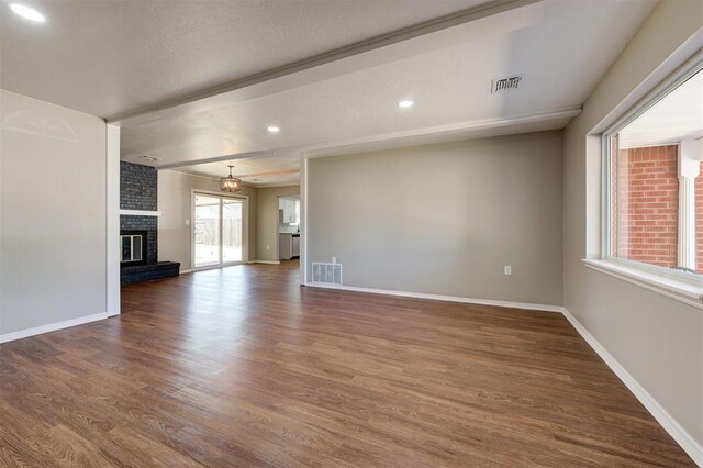1508 Carlton Way, Oklahoma City, OK 73120 - unfurnished living room featuring baseboards, visible vents, wood finished floors, and a fireplace