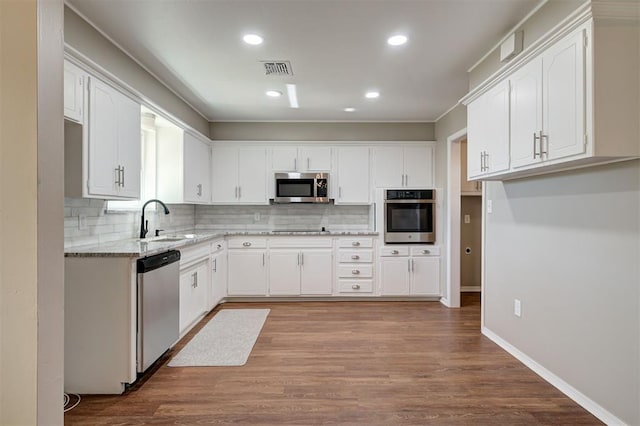 1508 Carlton Way, Oklahoma City, OK 73120 - kitchen with visible vents, tasteful backsplash, a sink, light stone counters, and stainless steel appliances