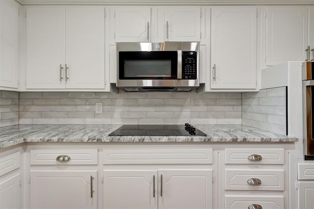 1508 Carlton Way, Oklahoma City, OK 73120 - kitchen with black electric cooktop, stainless steel microwave, and white cabinets