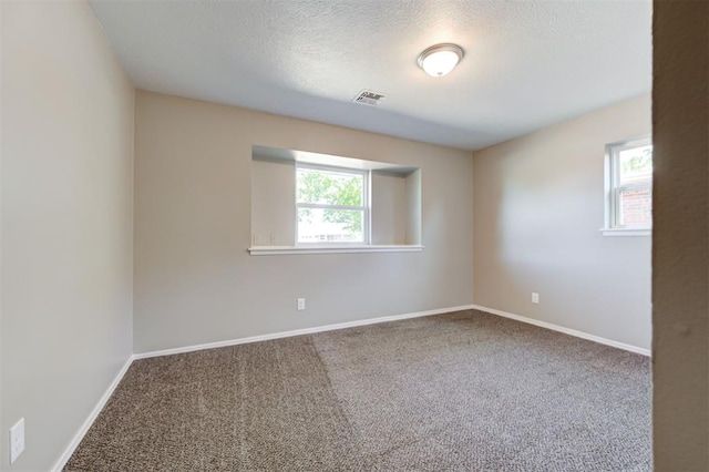 1508 Carlton Way, Oklahoma City, OK 73120 - empty room featuring carpet flooring, a textured ceiling, visible vents, and a healthy amount of sunlight