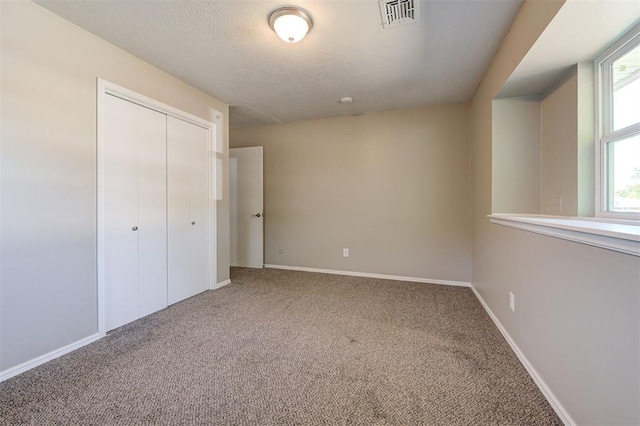 1508 Carlton Way, Oklahoma City, OK 73120 - unfurnished bedroom with a textured ceiling, visible vents, baseboards, a closet, and carpet flooring