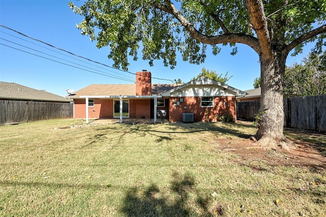 1508 Carlton Way, Oklahoma City, OK 73120 - back of property featuring a fenced backyard, a chimney, brick siding, central air condition unit, and a yard