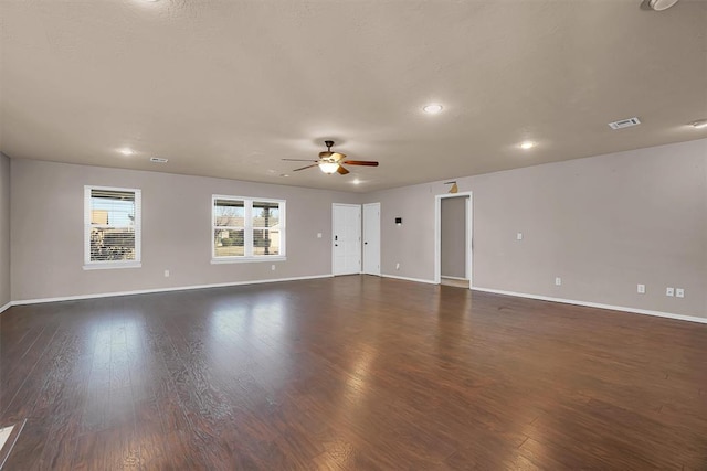 unfurnished living room with baseboards, ceiling fan, dark wood finished floors, and visible vents
