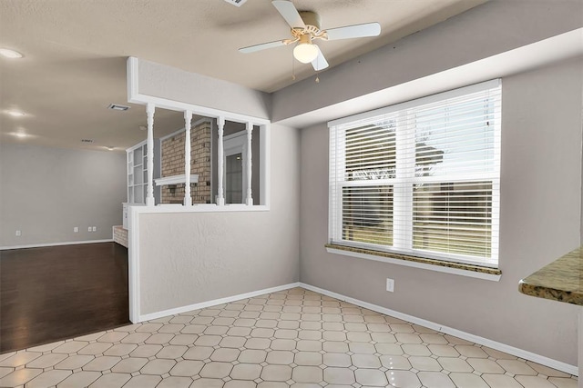 spare room featuring baseboards, ceiling fan, a healthy amount of sunlight, and light floors