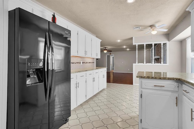 kitchen featuring ceiling fan, a textured ceiling, visible vents, black fridge with ice dispenser, and light floors