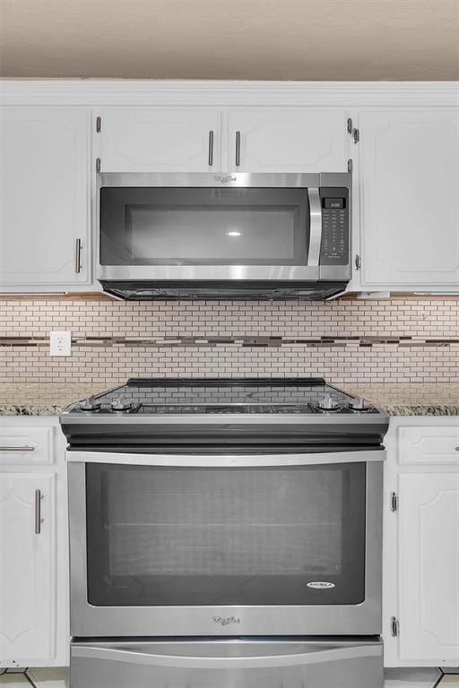 kitchen featuring white cabinets, tasteful backsplash, light stone countertops, and stainless steel appliances