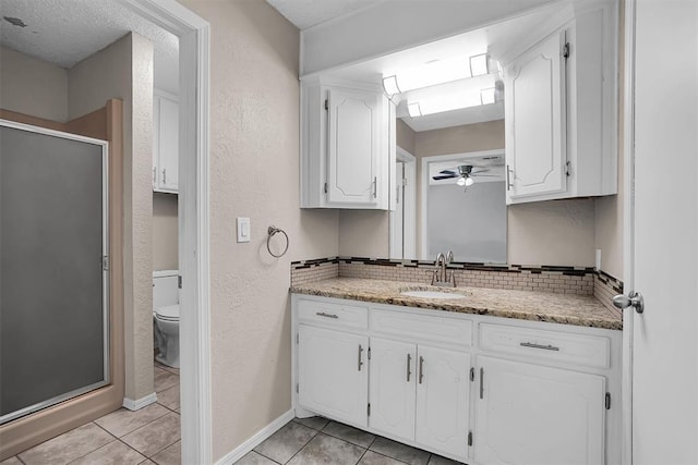 full bath with vanity, a textured wall, tile patterned floors, a shower stall, and backsplash