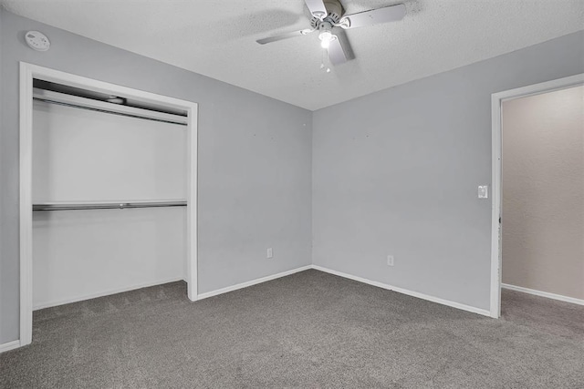 unfurnished bedroom with carpet flooring, a textured ceiling, a ceiling fan, baseboards, and a closet