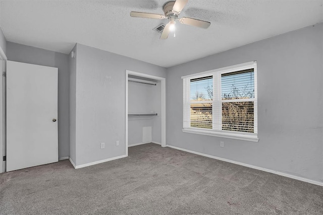 unfurnished bedroom with carpet floors, a textured ceiling, and a closet