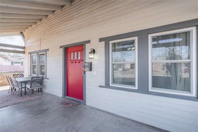 view of exterior entry with outdoor dining space and a porch