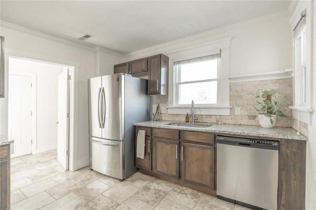 kitchen with crown molding, appliances with stainless steel finishes, a sink, backsplash, and visible vents