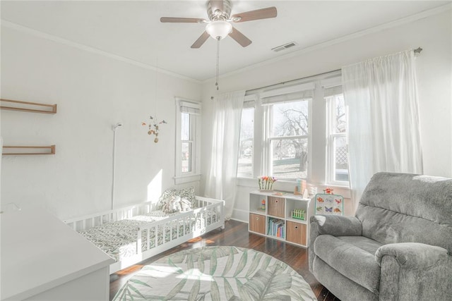 interior space featuring visible vents, ornamental molding, ceiling fan, and wood finished floors