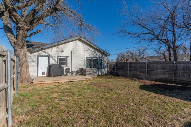 rear view of property featuring a yard and a fenced backyard
