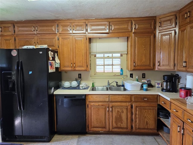 kitchen with a sink, brown cabinetry, and black appliances