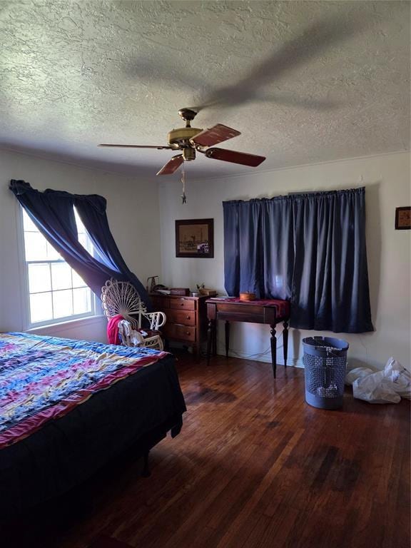 bedroom with a ceiling fan, a textured ceiling, and wood finished floors