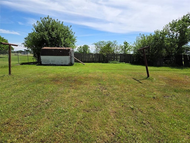 view of yard with a storage shed, fence, and an outbuilding