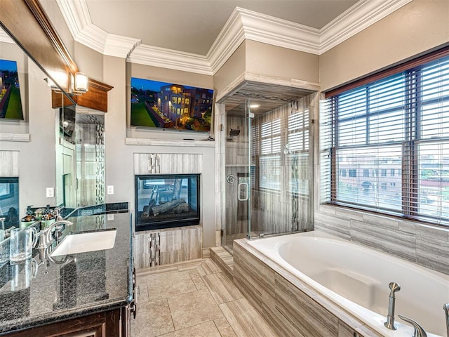 319 NE 1st St, Oklahoma City, OK 73104 - bathroom featuring vanity, a glass covered fireplace, ornamental molding, a garden tub, and a stall shower