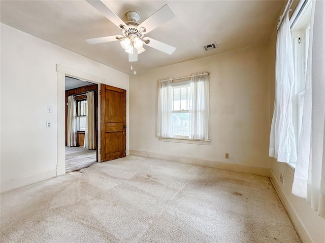 903 Sunset Dr, El Reno, OK 73036 - carpeted spare room featuring ceiling fan, visible vents, plenty of natural light, and baseboards
