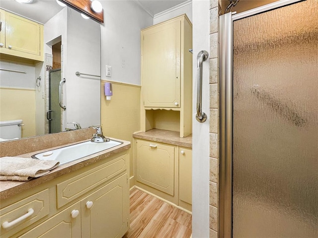 903 Sunset Dr, El Reno, OK 73036 - bathroom with a stall shower, wood finished floors, vanity, toilet, and ornamental molding