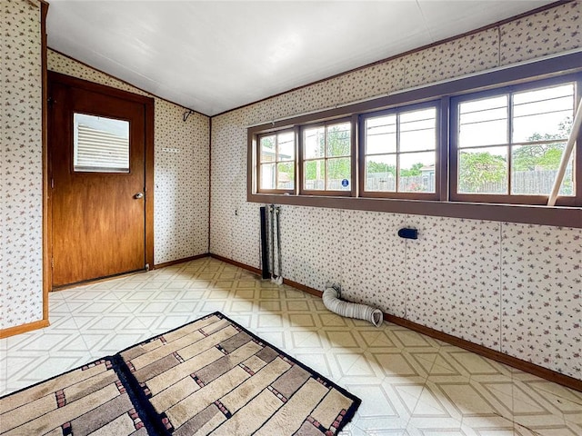 903 Sunset Dr, El Reno, OK 73036 - unfurnished room with baseboards, light floors, vaulted ceiling, and wallpapered walls