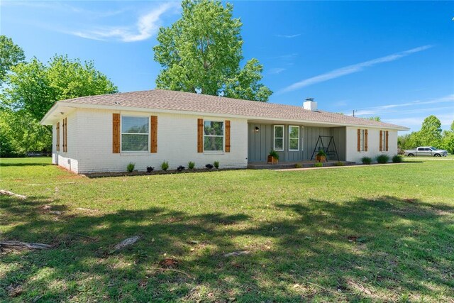 5606 E Tyler Dr, Tuttle, OK 73089 - single story home with board and batten siding, a chimney, a front lawn, and brick siding