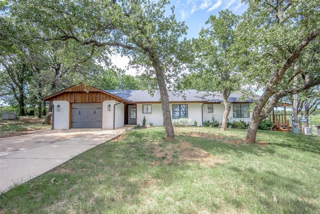 ranch-style house featuring a garage, concrete driveway, and a front yard