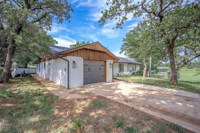 exterior space featuring brick siding, driveway, and a garage