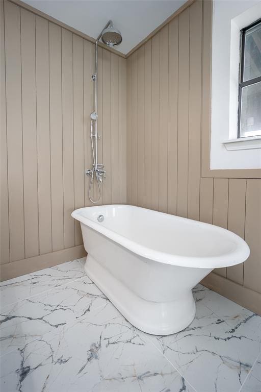 bathroom featuring a freestanding bath and marble finish floor
