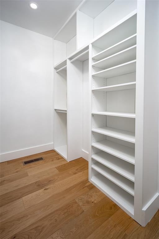 spacious closet featuring visible vents and light wood-type flooring