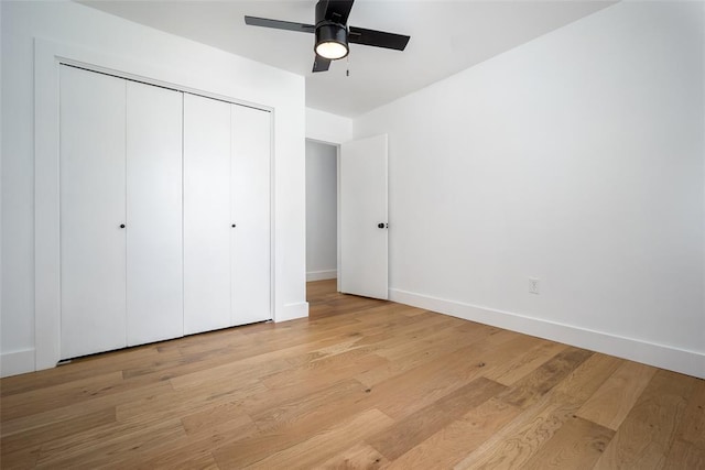 unfurnished bedroom with a ceiling fan, light wood-style floors, baseboards, and a closet